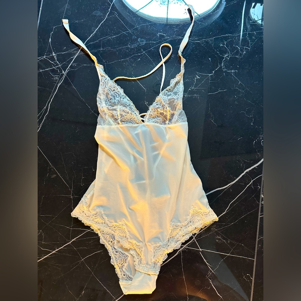 White bodysuit with bow in the back and neck strap. Never worn